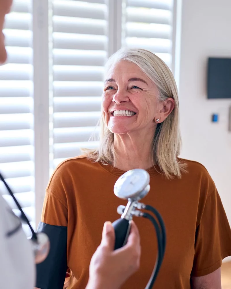 A nurse taking an older patient’s blood pressure