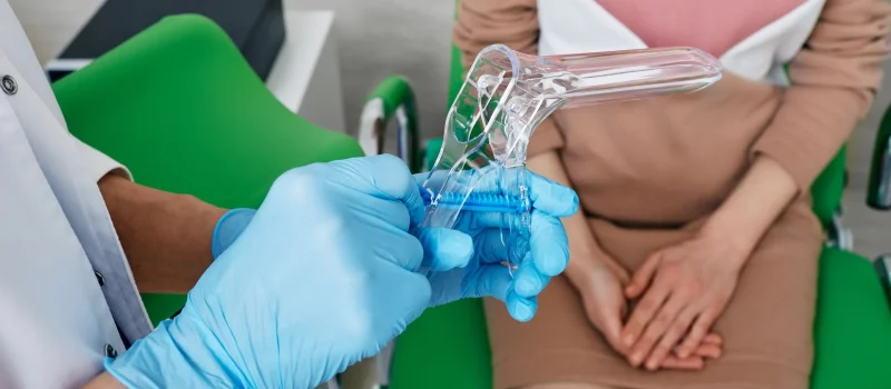 A gynaecologist holding a disposable speculum