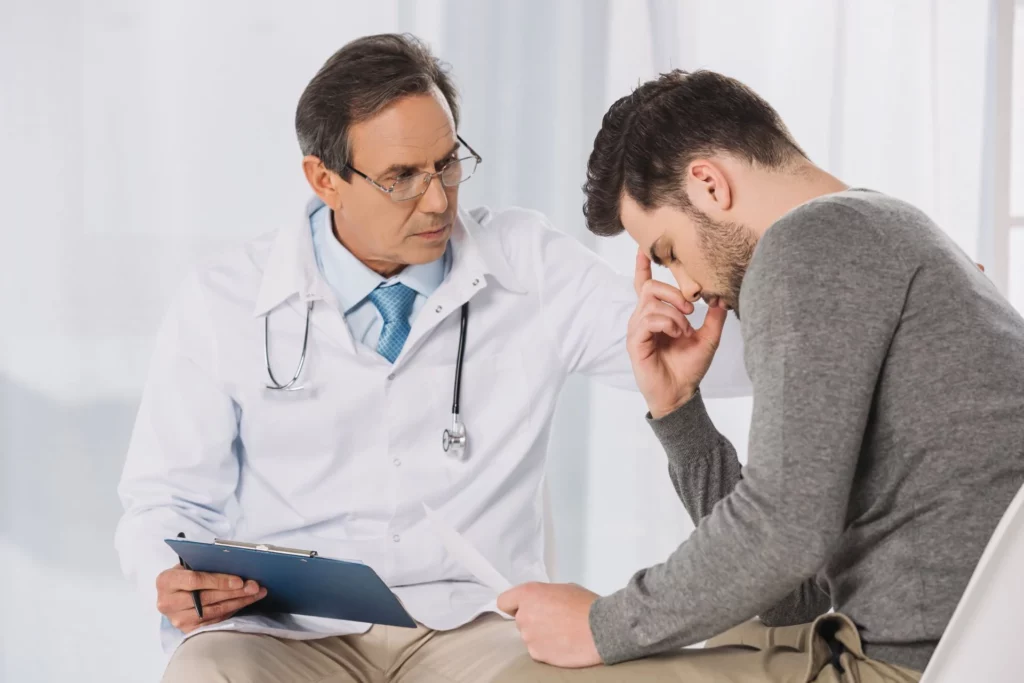 A doctor resting a hand on a patient’s shoulder